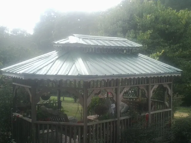 Two tier green metal roof on a garden gazebo in Hortense